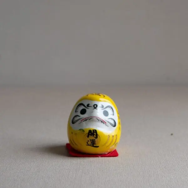 Mini daruma japonés amarillo